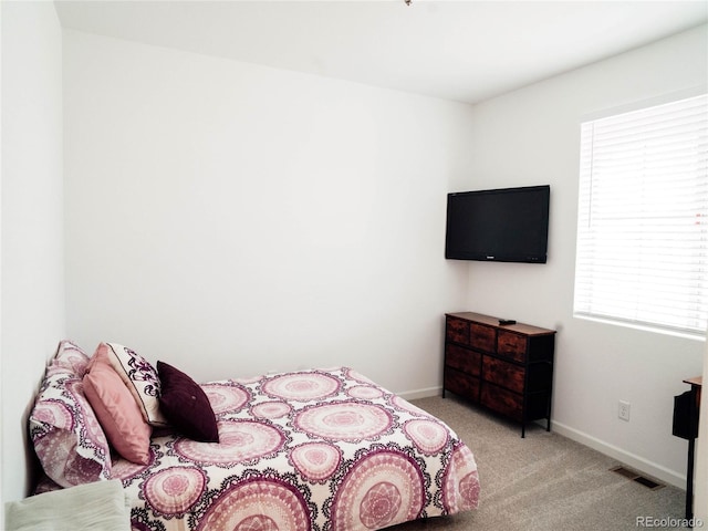 bedroom featuring baseboards, visible vents, and carpet