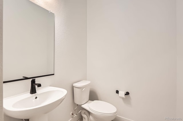6791 Navajo Ct, Denver, CO 80221 - half bath featuring baseboards, a sink, and toilet