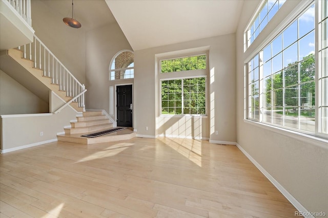 9602 Indian Wells Dr, Lone Tree, CO 80124 - foyer with plenty of natural light, high vaulted ceiling, hardwood / wood-style flooring, and baseboards