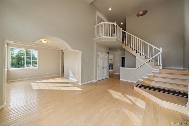 9602 Indian Wells Dr, Lone Tree, CO 80124 - entryway with a high ceiling, stairway, wood-type flooring, arched walkways, and baseboards