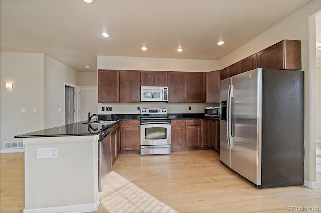 9602 Indian Wells Dr, Lone Tree, CO 80124 - kitchen featuring appliances with stainless steel finishes, light wood-type flooring, dark countertops, a sink, and recessed lighting