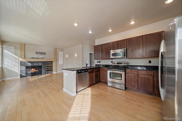 9602 Indian Wells Dr, Lone Tree, CO 80124 - kitchen featuring appliances with stainless steel finishes, a sink, open floor plan, dark countertops, and recessed lighting