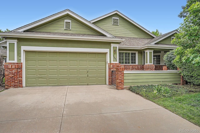 1851 S Marshall Cir, Lakewood, CO 80232 - view of front of property with brick siding, concrete driveway, a garage, and a shingled roof