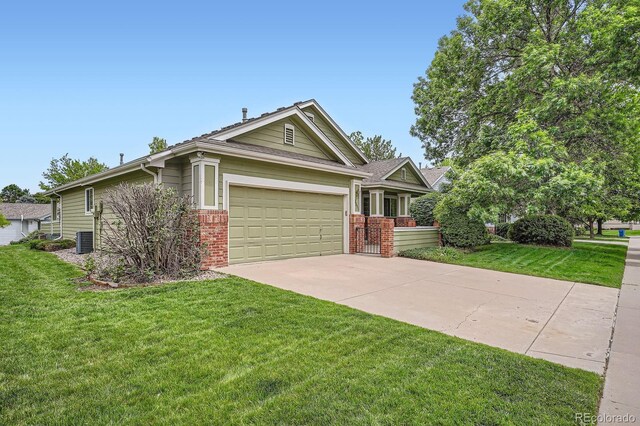 1851 S Marshall Cir, Lakewood, CO 80232 - view of front of home with concrete driveway, brick siding, a front lawn, and an attached garage
