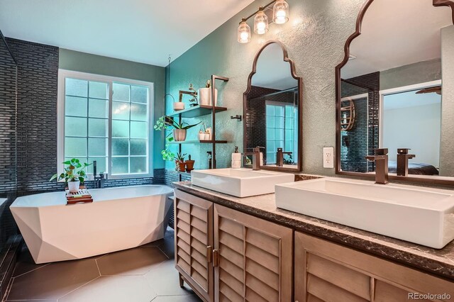 1851 S Marshall Cir, Lakewood, CO 80232 - full bath with a soaking tub, double vanity, a textured wall, and tile patterned flooring