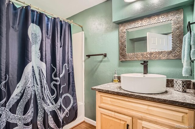 1851 S Marshall Cir, Lakewood, CO 80232 - bathroom featuring vanity, a textured wall, and wood finished floors