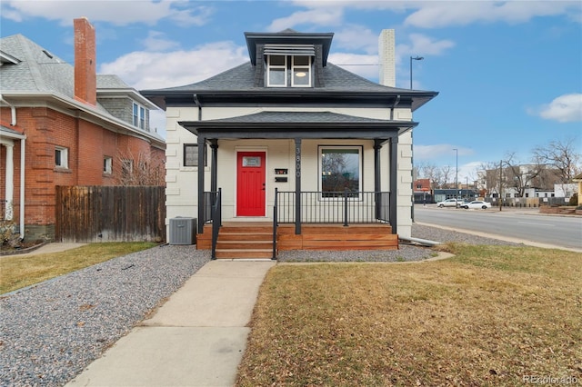 view of front of house featuring a porch, central AC, fence, and a front lawn