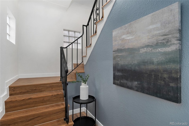 stairway featuring wood finished floors and baseboards