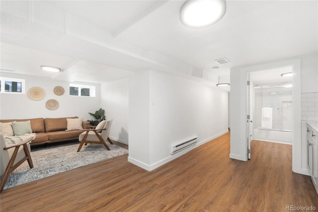 hall with baseboards, visible vents, a baseboard heating unit, and wood finished floors