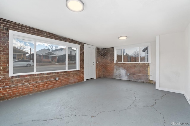 interior space with concrete floors and brick wall