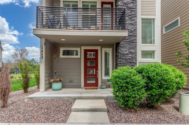 15843 E Broncos Pl, Englewood, CO 80112 - view of exterior entry featuring a balcony and stone siding
