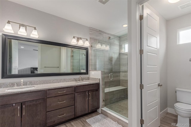 15843 E Broncos Pl, Englewood, CO 80112 - bathroom with a shower stall, wood finished floors, toilet, and double vanity