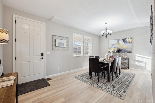 dining area featuring an inviting chandelier and light wood-type flooring