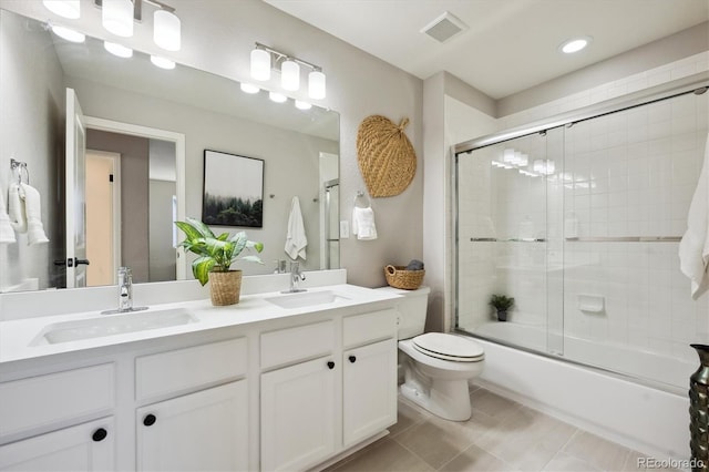 full bathroom featuring vanity, tile patterned flooring, bath / shower combo with glass door, and toilet