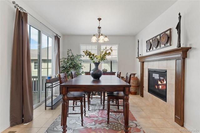 tiled dining space with a tile fireplace and a notable chandelier