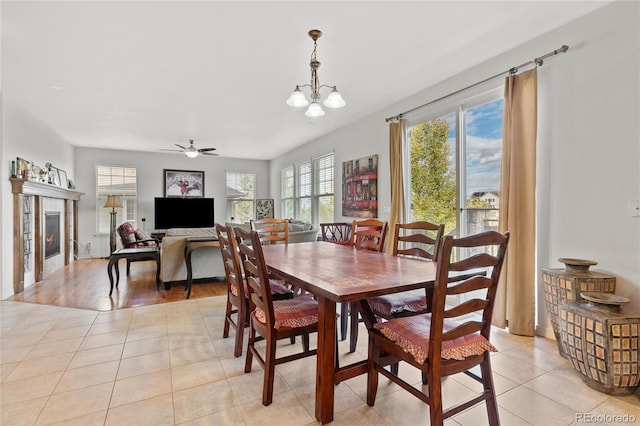 6470 S Ider St, Aurora, CO 80016 - dining room with a ceiling fan, light tile patterned floors, a tile fireplace, and a chandelier
