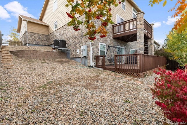 6470 S Ider St, Aurora, CO 80016 - back of house with stone siding, a wooden deck, and central air condition unit