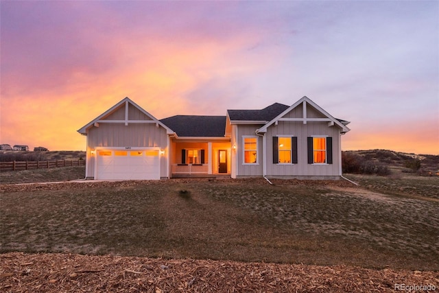 5693 Missoula Trl, Castle Rock, CO 80108 - view of front of home with an attached garage, covered porch, board and batten siding, and dirt driveway