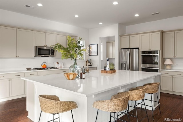 5693 Missoula Trl, Castle Rock, CO 80108 - kitchen with appliances with stainless steel finishes, dark wood-style flooring, light countertops, recessed lighting, and a breakfast bar area