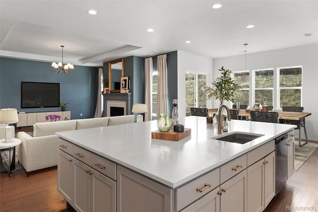 5693 Missoula Trl, Castle Rock, CO 80108 - kitchen featuring a chandelier, wood finished floors, recessed lighting, a center island with sink, and light countertops