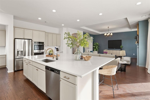 5693 Missoula Trl, Castle Rock, CO 80108 - kitchen featuring appliances with stainless steel finishes, open floor plan, dark wood finished floors, recessed lighting, and a kitchen island with sink