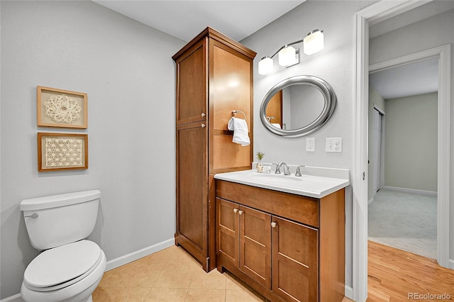 bathroom with toilet, vanity, and baseboards