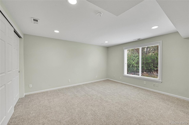carpeted empty room featuring baseboards and recessed lighting