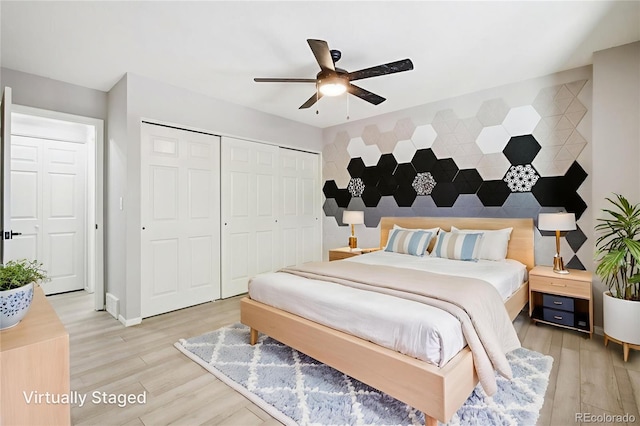 1707 Ostia Cir Unit 46, Lafayette, CO 80026 - bedroom featuring light wood-type flooring, a closet, an accent wall, and ceiling fan