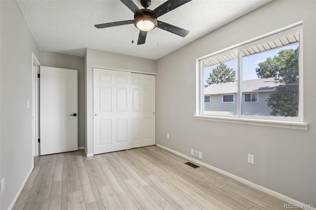 1707 Ostia Cir Unit 46, Lafayette, CO 80026 - unfurnished bedroom featuring wood finished floors, a closet, a textured ceiling, and a ceiling fan
