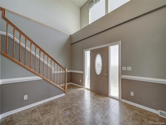 tiled entrance foyer featuring a towering ceiling