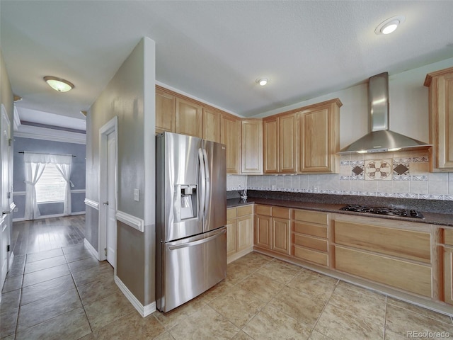 kitchen featuring light brown cabinetry, wall chimney range hood, and stainless steel appliances