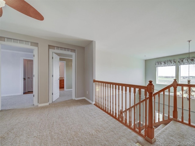 corridor featuring carpet flooring and a chandelier