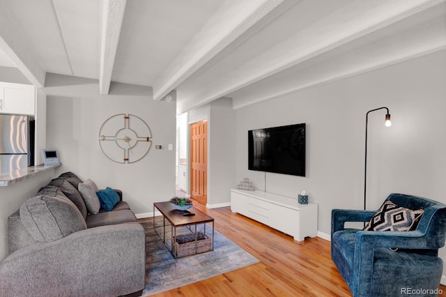 living room with light wood-type flooring, beam ceiling, and baseboards