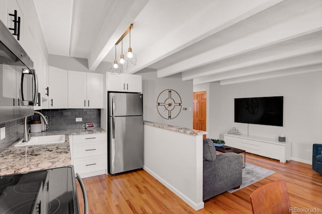 kitchen with beam ceiling, black range with electric stovetop, a sink, open floor plan, and freestanding refrigerator