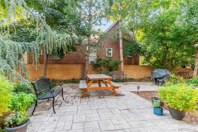 view of patio with outdoor dining space, area for grilling, and fence