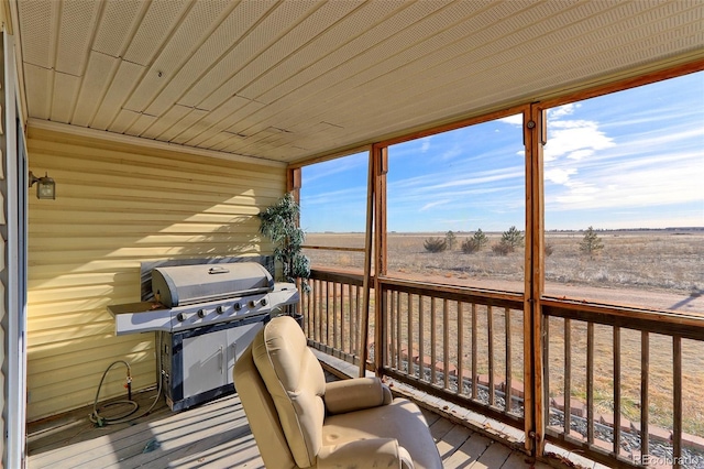 wooden deck with a rural view and a grill