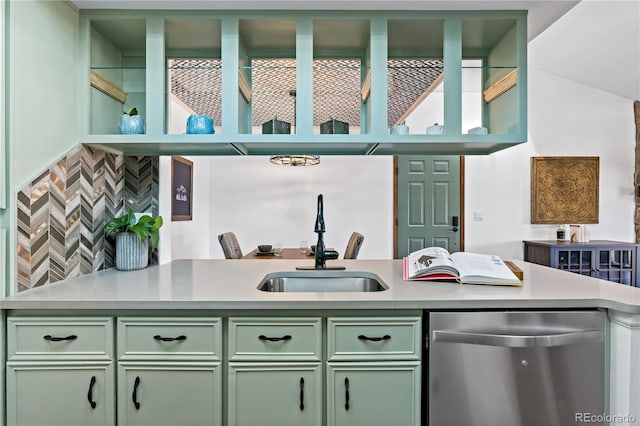 kitchen with dishwasher, light countertops, a sink, decorative backsplash, and green cabinetry