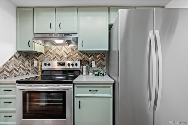kitchen with tasteful backsplash, green cabinetry, light countertops, under cabinet range hood, and stainless steel appliances