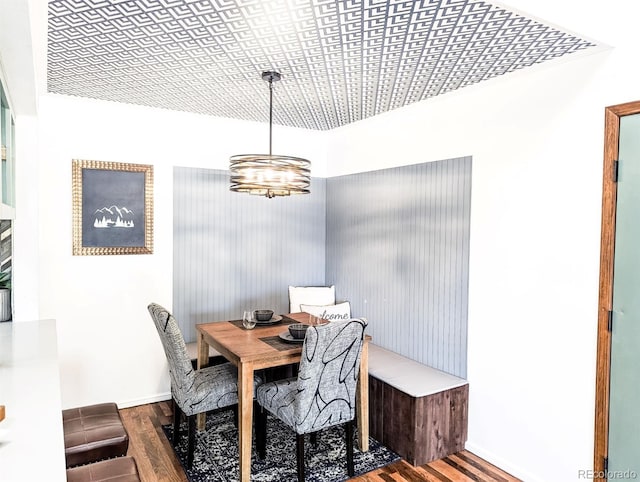dining room featuring baseboards, an inviting chandelier, and wood finished floors