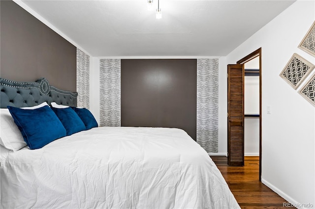 bedroom with baseboards and wood finished floors