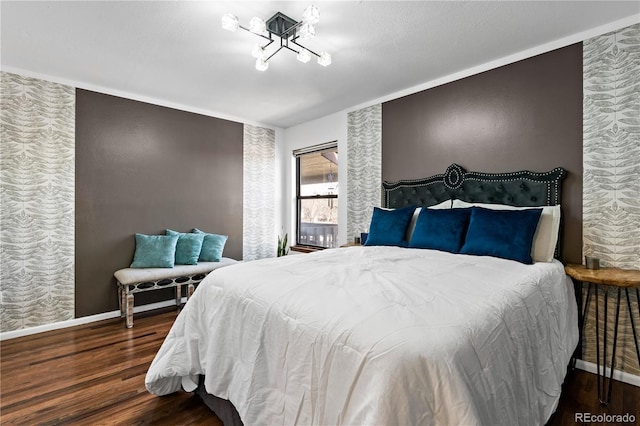 bedroom with wood finished floors, an inviting chandelier, and baseboards
