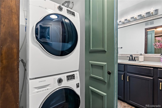 laundry area with stacked washer / dryer, visible vents, and a sink
