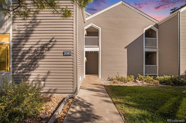 exterior space featuring a lawn and a balcony