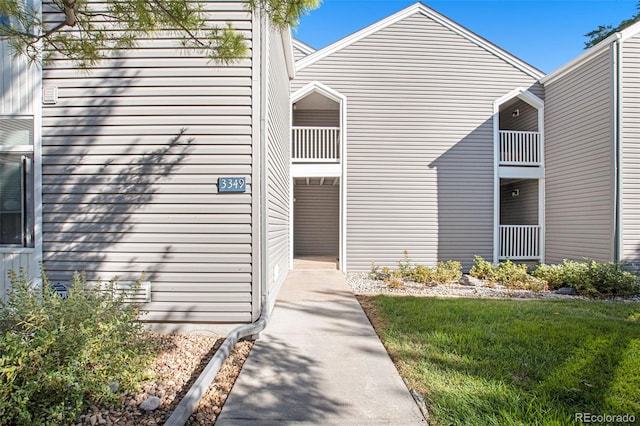 exterior space with a balcony and a lawn