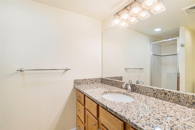 bathroom with a shower with door and vanity