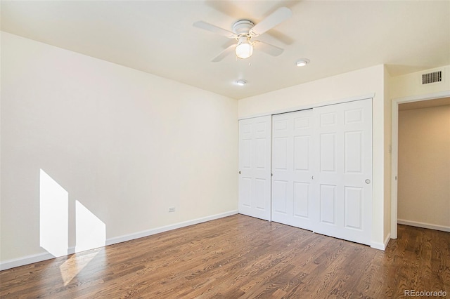 unfurnished bedroom with a closet, ceiling fan, and dark hardwood / wood-style flooring