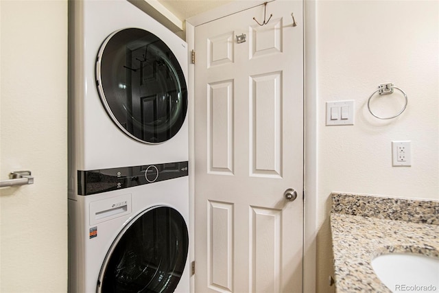 clothes washing area with stacked washer / dryer and sink