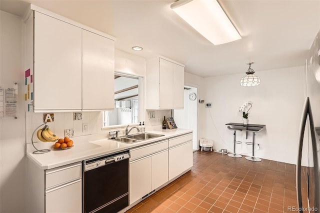 kitchen with white cabinets, dishwasher, light countertops, pendant lighting, and a sink