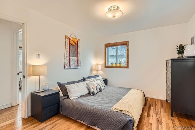 bedroom with light wood-style floors and baseboards