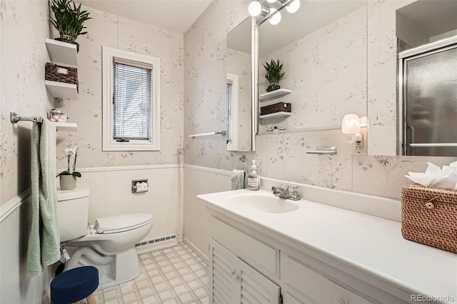 bathroom featuring a wainscoted wall, vanity, toilet, and wallpapered walls